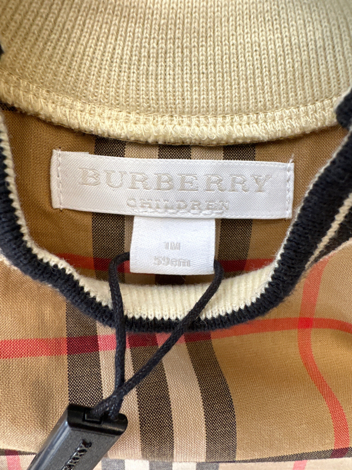 Burberry Babyanzug in Beige mit Karomuster, Nahaufnahme des Marken- und Größenetiketts für 1 Monat