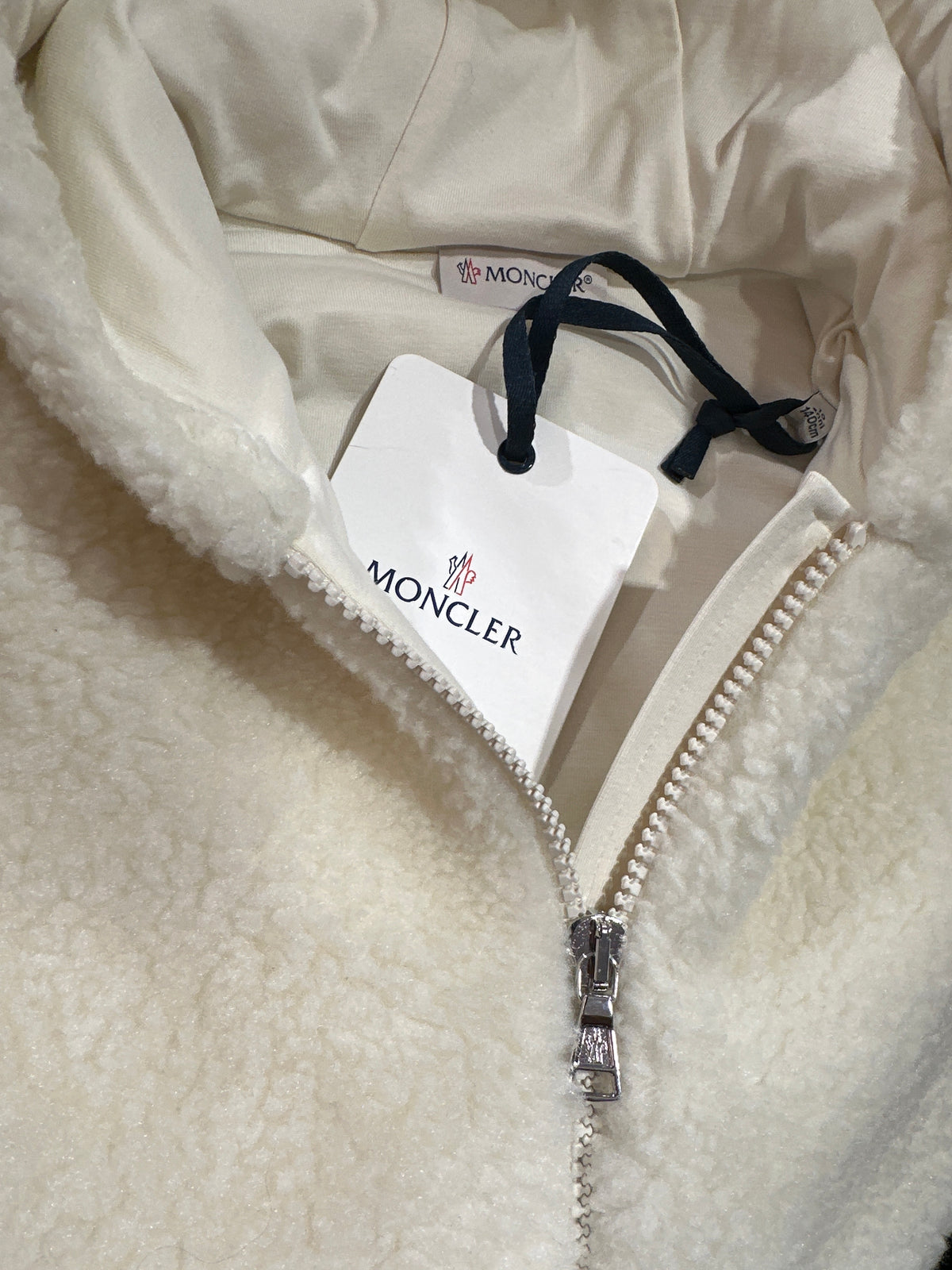 Moncler Designer-Teddyjacke Creme, Unisex, 10 Jahre, Detail von Reißverschluss, Markenetikett und Anhänger